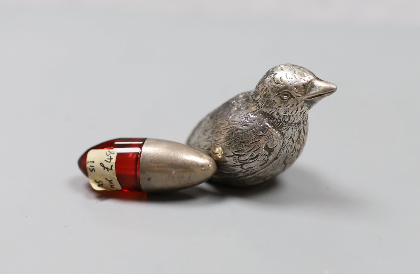 An Edwardian silver mounted ruby glass scent bottle, 4cm and a silver overlaid bird paperweight, 5cm
